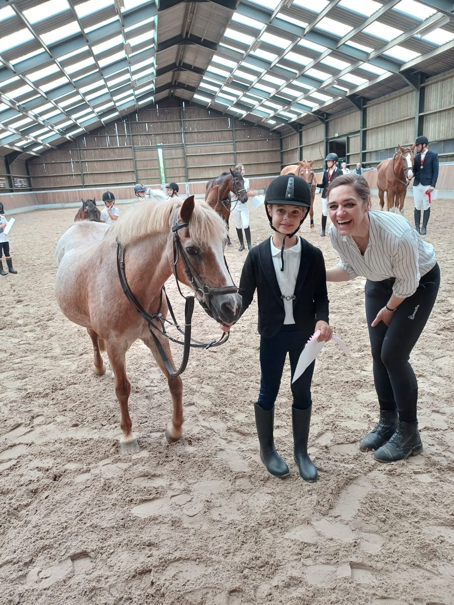 Ruiter met pony en instructrice bij de Bixi-wedstrijd